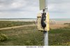 an-isolated-phone-on-a-pole-by-the-beach-dfk52g.jpg