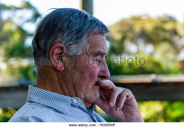 an-elderly-man-rests-on-a-shady-balcony-deep-in-thought-hgw5hf.jpg